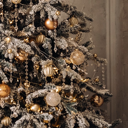 Full-length Christmas tree. On New year's eve, a snow-covered Christmas tree stands at home